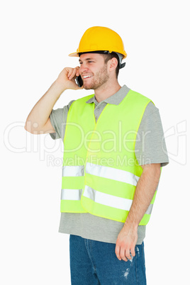 Smiling young construction worker on the cellphone