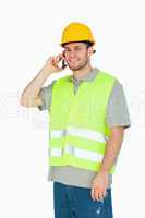 Smiling young construction worker on the mobile phone