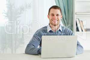 Smiling young businessman working in his homeoffice