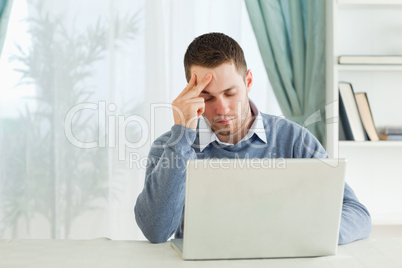 Tired businessman on his laptop in his homeoffice