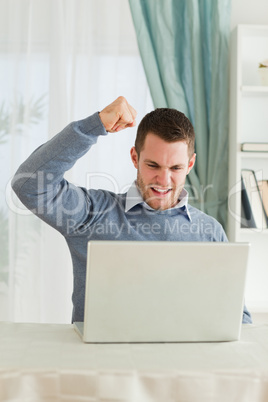 Businessman with raised fist in his homeoffice