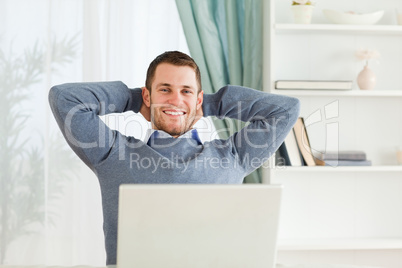 Smiling businessman leaning back in his homeoffice