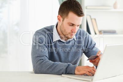 Male entering credit card information in his laptop