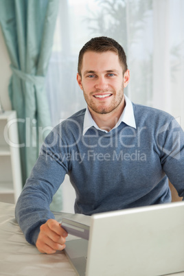 Smiling male happy about his online shopping
