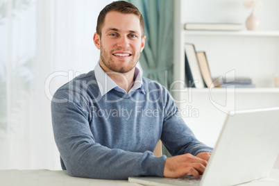 Smiling businessman with laptop in his homeoffice