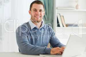 Smiling businessman with laptop in his homeoffice