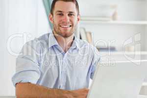 Smiling businessman with rolled up sleeves in his homebusiness