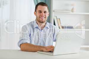 Businessman with rolled up sleeves on his laptop in his homeoffi