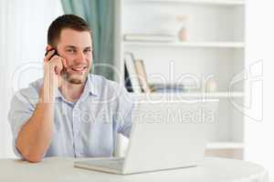 Smiling businessman on the phone in his homeoffice