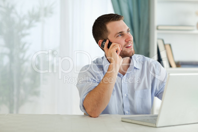 Businessman with his cellphone in his homeoffice