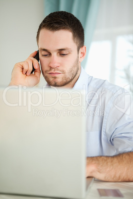 Businessman in his homeoffice using his cellphone