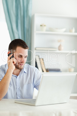 Businessman on his cellphone while working on his laptop