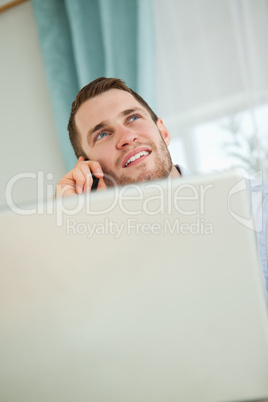 Young businessman on the phone in his homeoffice