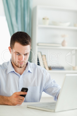 Businessman reading text message in his homeoffice