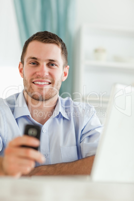 Smiling businessman with his cellphone