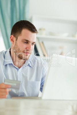 Businessman with credit card and laptop in his homeoffice