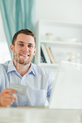 Businessman with credit card and notebook in his homeoffice