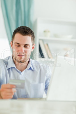 Businessman with laptop and credit card in his homeoffice