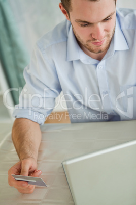 Businessman with credit card on his laptop