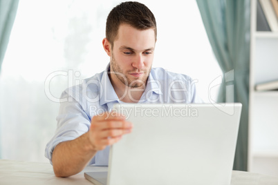 Businessman sitting behind his table on his laptop