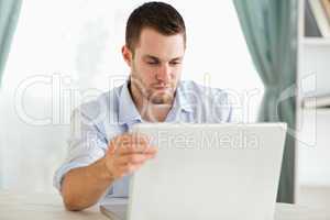 Businessman sitting behind his table on his laptop