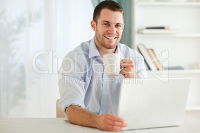 Smiling businessman having a cup of tea