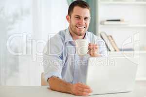 Smiling businessman having a cup of tea