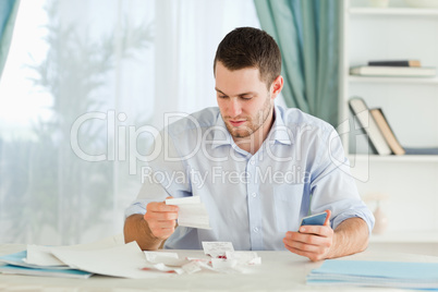 Businessman with calculator checking bills