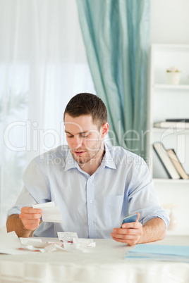 Businessman with hand calculator checking bills