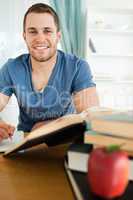 Smiling student with his assignment in front of him