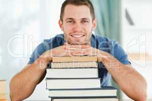 Smiling student leaning on his books
