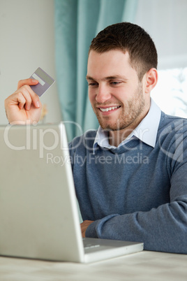 Man with his credit card on his laptop