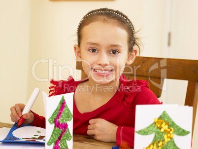 Young mixed race child making Christmas cards