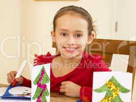 Young mixed race child making Christmas cards