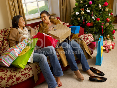 Hispanic mother and daughter resting after Christmas shopping
