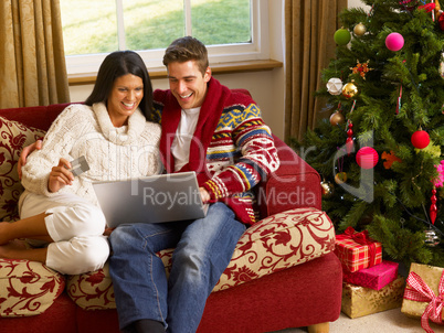 Young Hispanic couple Christmas shopping online