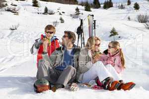 Young Family Sharing A Picnic On Ski Vacation