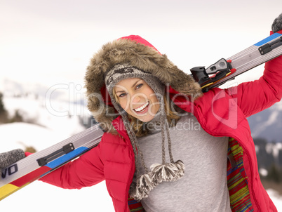 Young Woman holding Skis In Alpine Landscape