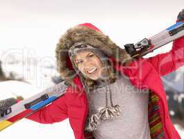 Young Woman holding Skis In Alpine Landscape