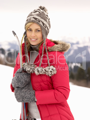 Young Woman holding Skis In Alpine Landscape