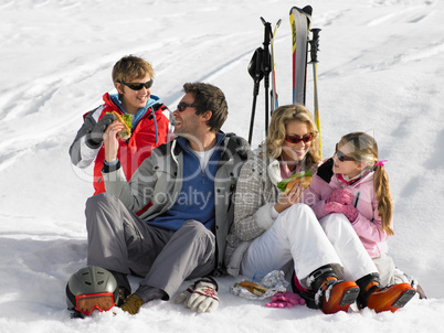 Young Family Sharing A Picnic On Ski Vacation