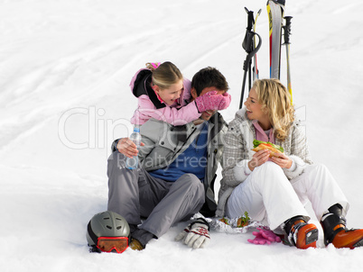 Young Family With Picnic On Ski Vacation