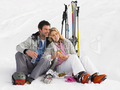 Young Couple With Picnic On Ski Vacation