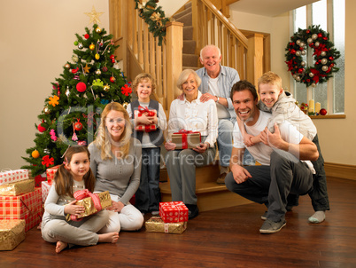 Family with gifts in front of Christmas tree
