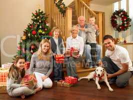 Family with gifts in front of Christmas tree