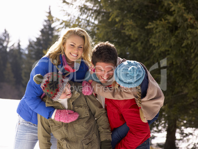 Young Family  In Alpine Snow Scene