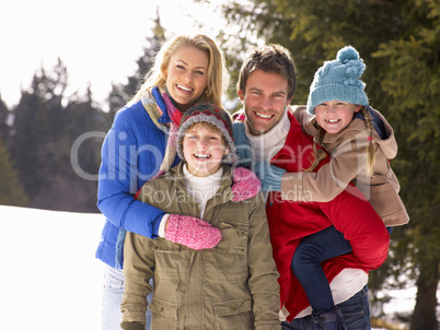 Young Family  In Alpine Snow Scene