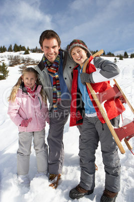 Young Father And Children In Snow With Sled
