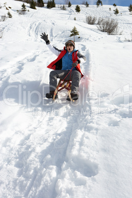 Pre-teen Boy On A Sled In The Snow