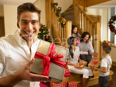 Hispanic family exchanging gifts at Christmas